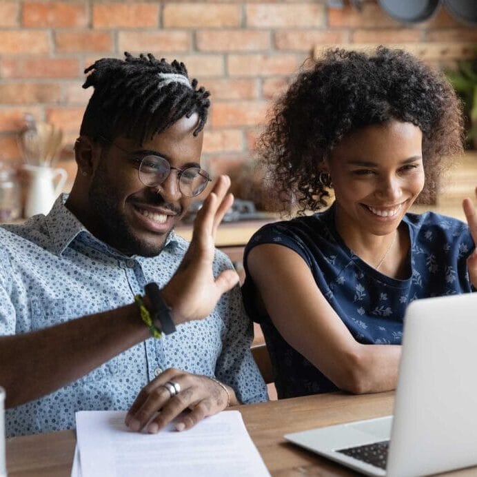 New Canada Connect A male and a female in front of a laptop waving their hands